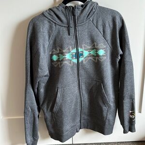 Dark grey Nike jacket zip up with turquoise chevron pattern on the front.